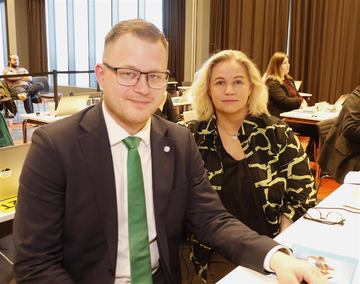 Bilde av mann med briller, dressjakke og grønt slips, og kvinne med lyst hår. - Klikk for stort bilde