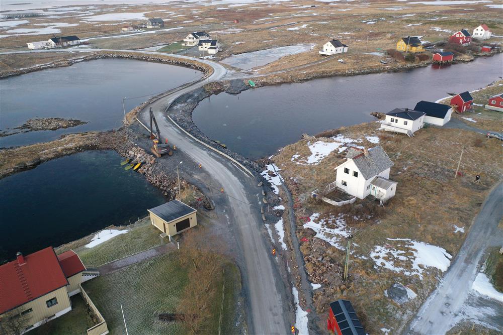 Lav bru, anleggsarbeid, boliger i flatt landskap. Vinter uten snø. Dronefoto. - Klikk for stort bilde