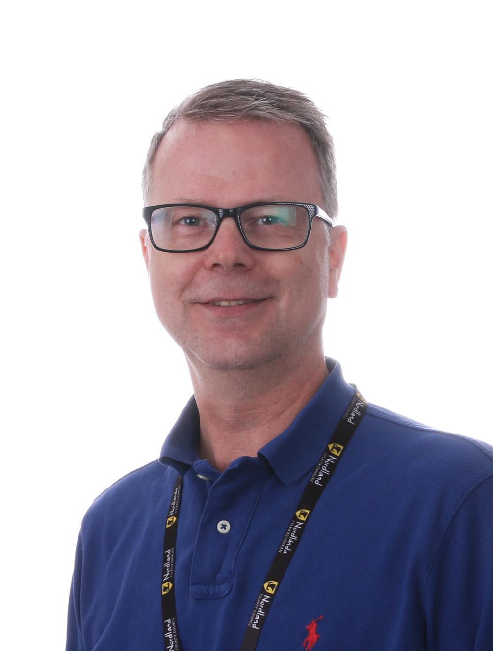 Portrett av ung mann i blå skjorte og briller. - Klikk for stort bilde