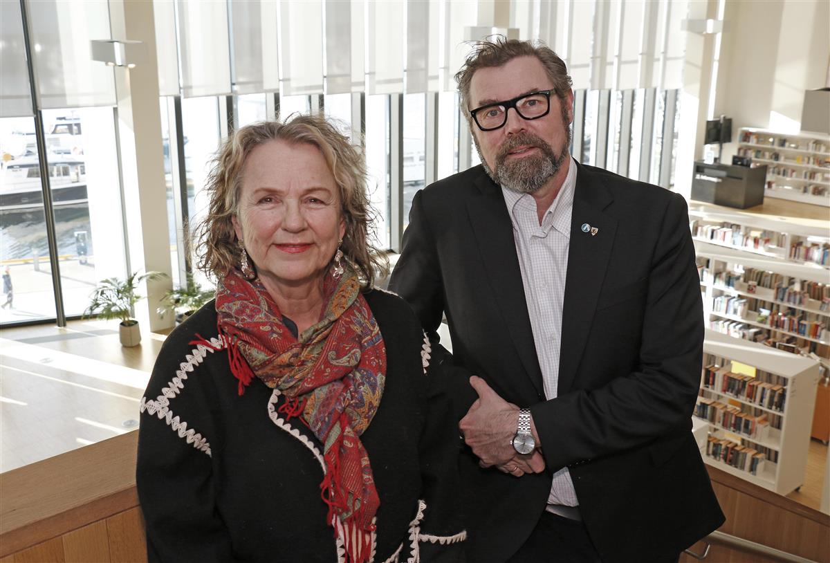 smilende kvinne og mann på bibliotek - Klikk for stort bilde