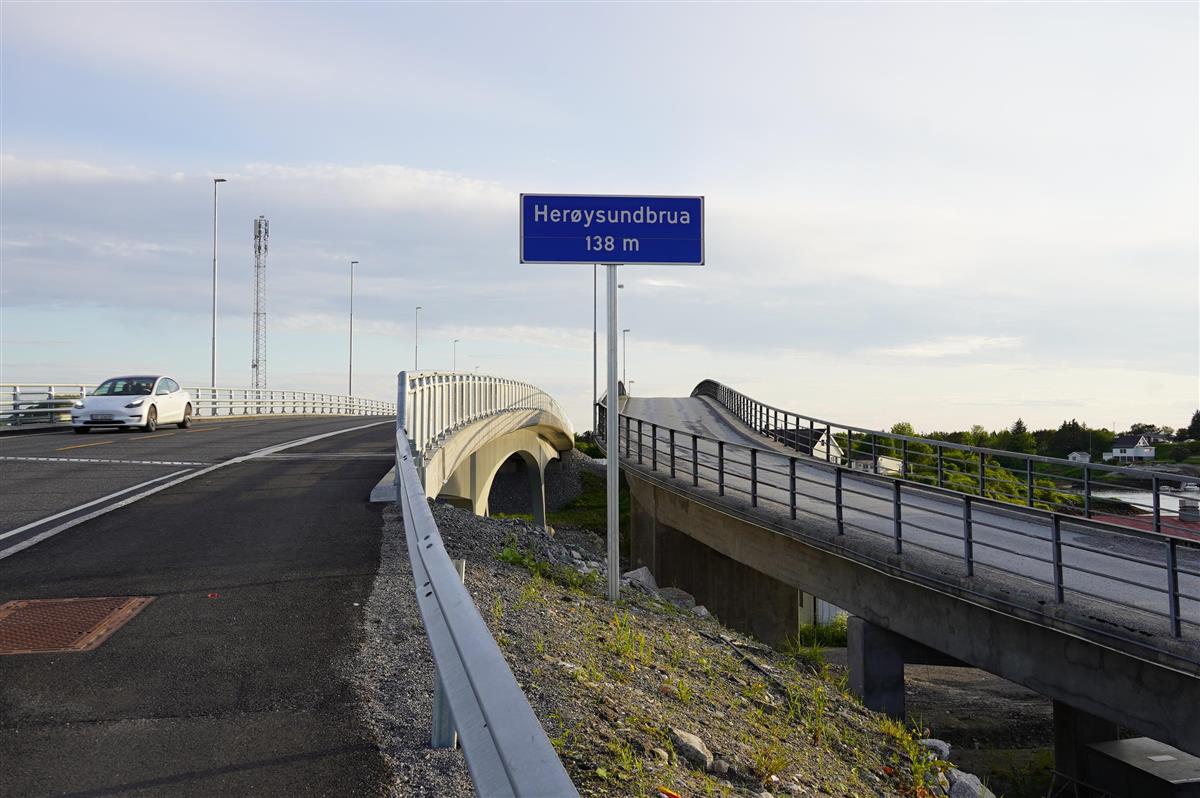 To bruer ved siden av hverandre, en bil på den ene. Skilt med Herøysundbrua. Foto.  - Klikk for stort bilde