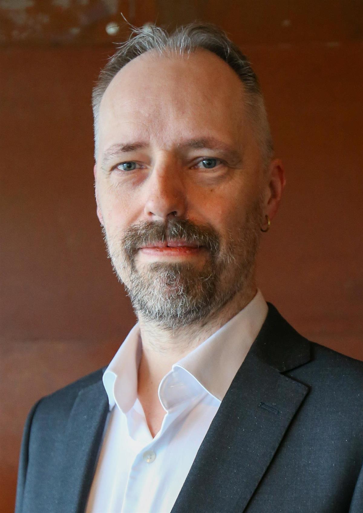 Bilde av mann med skjegg, hvit skjorte og blazer. - Klikk for stort bilde