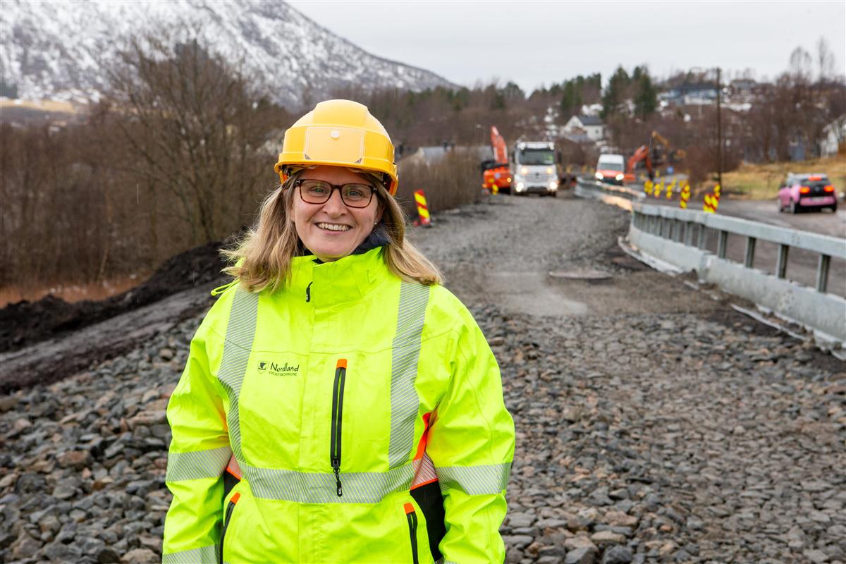Dame kledd i gule arbeidsklær på gang- og sykkelvei under bygging. - Klikk for stort bilde