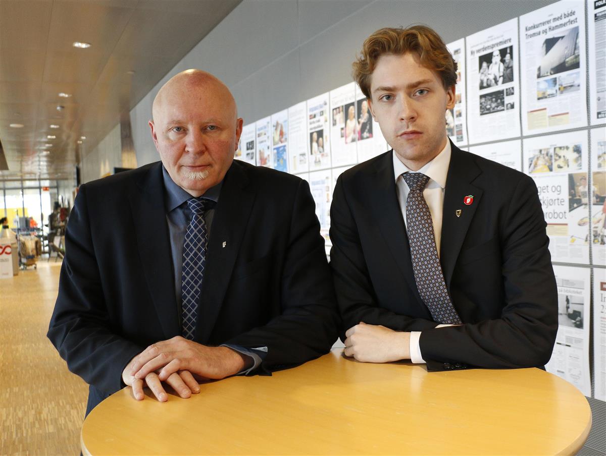 To alvorlige menn i dressjakke bak bord. Foto. - Klikk for stort bilde
