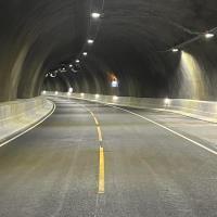 Inne i en tunnel ved en havarilomme,  ingen kjøretøy.  Tente lys i tak og langs veggen til høyre.  - Klikk for stort bilde